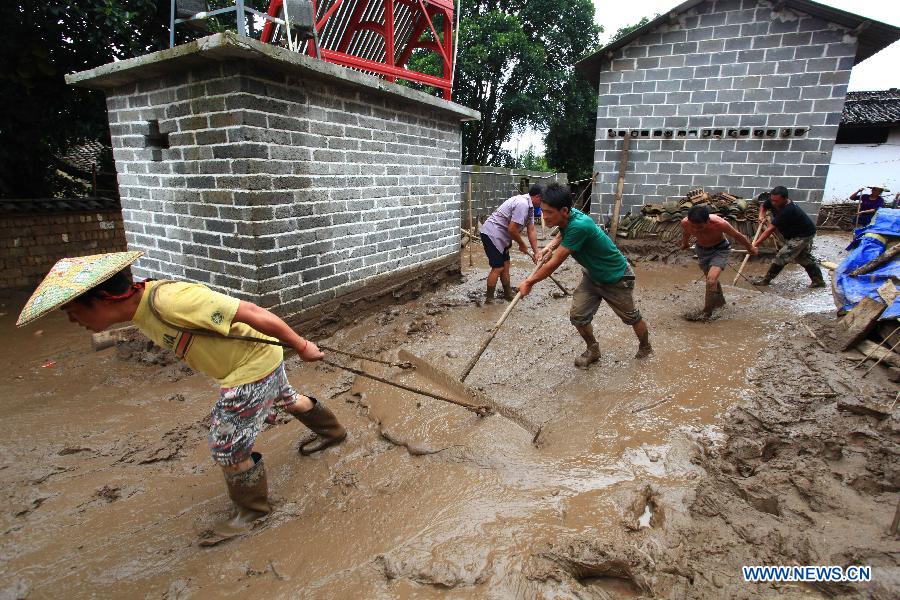 Villagers clear silt in Fanmeng Village of Yingjiang County, southwest China's Yunnan Province, June 24, 2012