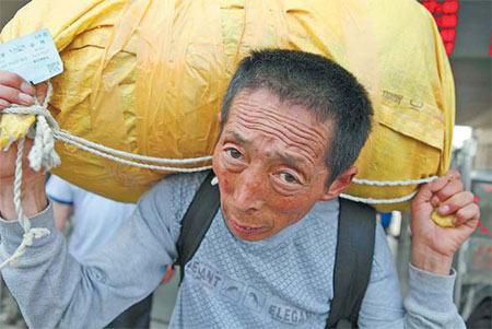 A migrant worker carries his bag as he leaves Bozhou Railway Station in Anhui province late last month.