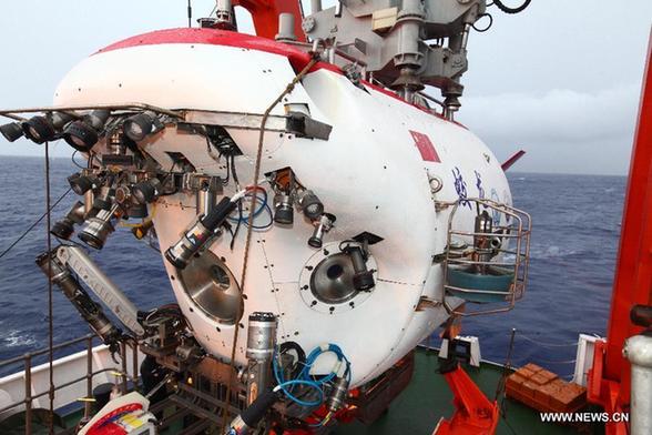 China's manned deep-sea submersible Jiaolong prepares to be put into water to make a fourth dive into the sea at the Mariana Trench on June 24, 2012. [ Photo / Xinhua ] 