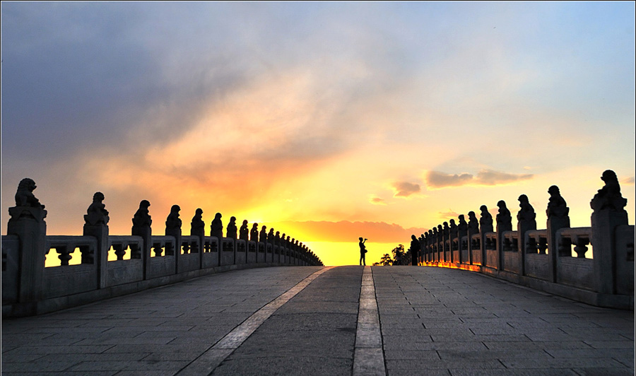 Built in 1950 during Emperor Qianlong's reign in the Qing Dynasty, the 150-meter long bridge links the eat bank and the South Lake Island in the Summer Palace. It is the longest bridge in any Chinese imperial garden and was named for its seventeen arches. Over 500 stone lions in different poses were carved on the posts of the bridge's railings.