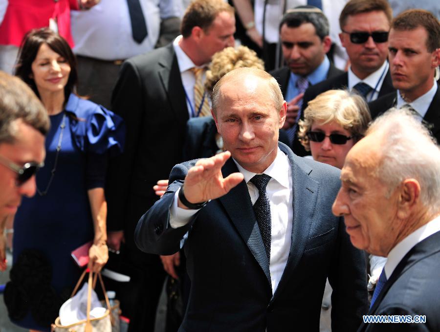 President Vladimir Putin waves to press during a ceremony to dedicate the 'Victory Monument' in Netanya, north Israel, on June 25, 2012.