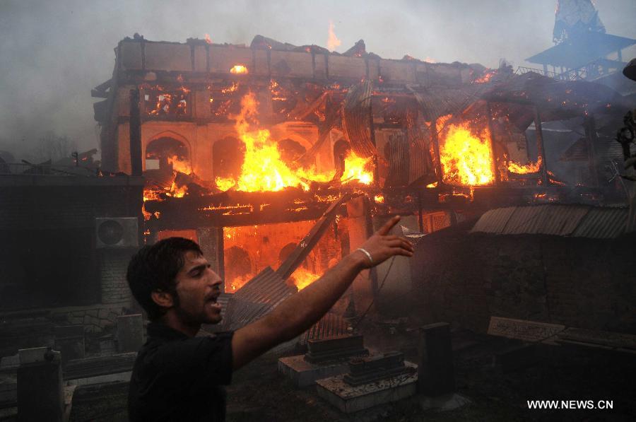 A young Kashmiri Muslim shouts for help as flames engulf the shrine of Sheikh Syed Abdul Qadir Jeelani in Srinagar, summer capital of Indian-controlled Kashmir, June 25, 2012. A 200-year-old Muslim Sufi shrine gutted in a fire incident Monday in Indian-controlled Kashmir, police said. The historical shrine of Sheikh Syed Abdul Qadir Jeelani ( locally called Dastgeer Sahib) is in old part of Srinagar city. 