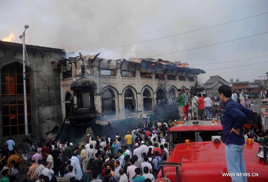 Local residents gather around the gutted shrine of Sheikh Syed Abdul Qadir Jeelani in Srinagar, summer capital of Indian-controlled Kashmir, June 25, 2012. A 200-year-old Muslim Sufi shrine gutted in a fire incident Monday in Indian-controlled Kashmir, police said. The historical shrine of Sheikh Syed Abdul Qadir Jeelani ( locally called Dastgeer Sahib) is in old part of Srinagar city.