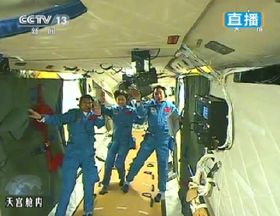 After a successful docking, the three Shenzhou 9 crew members enter the space lab to perform a series of scheduled scientific experiments. [ Photo/ Xinhua ]