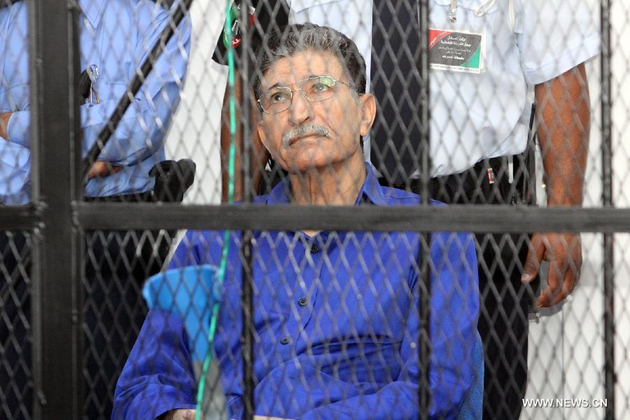 Bouzid Dorda (R), the intelligence chief of Libya's former regime, sits inside a cage during his trial at a court in Tripoli, Libya, June 26, 2012.