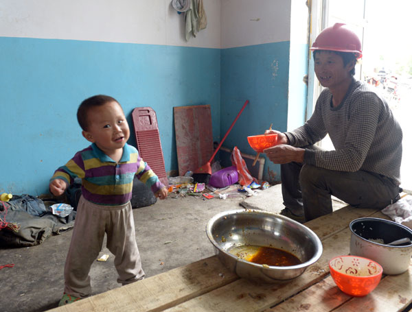 Liu Jun, a migrant worker from Henan province, plays with his child recently at a construction site in Hami, the Xinjiang Uygur autonomous region. Zhang Jiangang/for China Daily