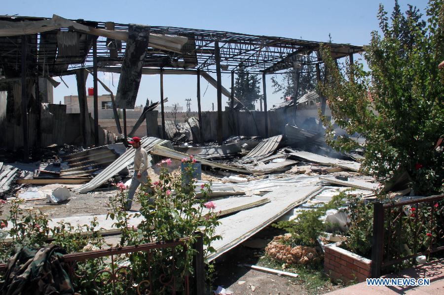 A man walks among the debris of the headquarters of al- Ekhbaria TV in a suburban area of the Syrian capital of Damascus on June 27, 2012.