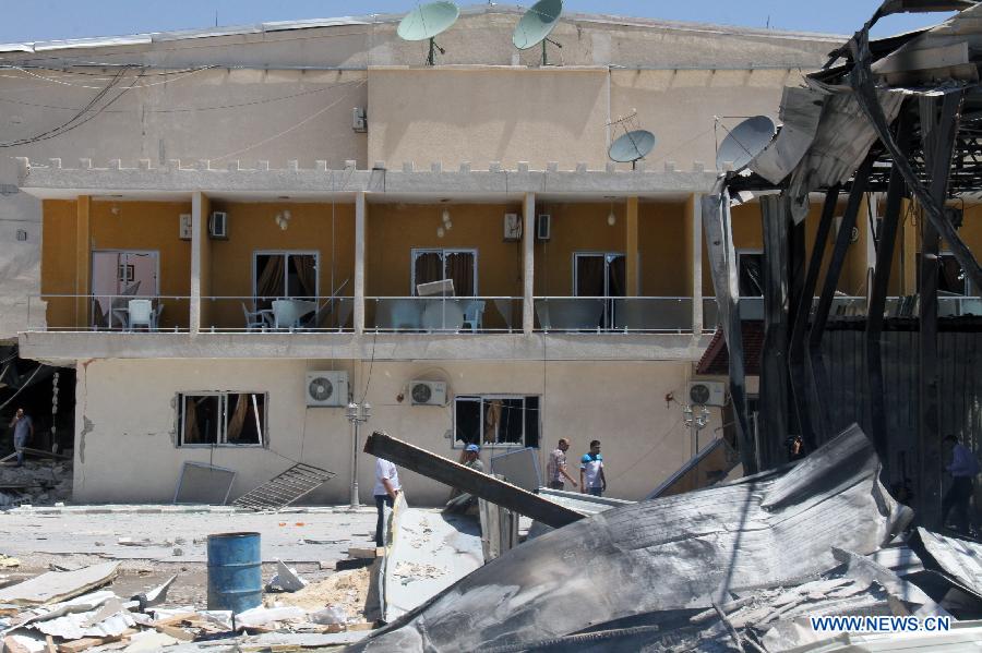 People inspect the damaged headquarters of al- Ekhbaria TV in a suburban area of the Syrian capital of Damascus on June 27, 2012.