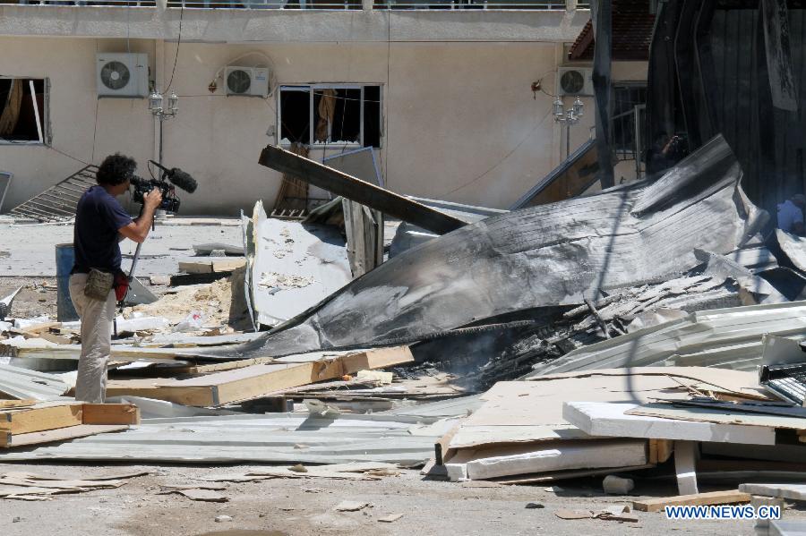 A cameraman shoots the debris of the headquarters of al- Ekhbaria TV in a suburban area of the Syrian capital of Damascus on June 27, 2012. 