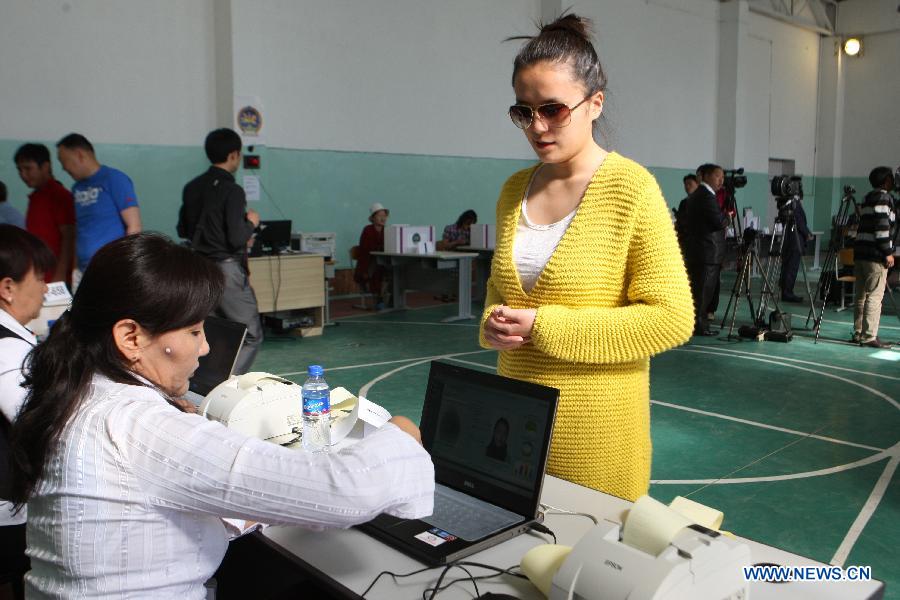 A woman is checked before casting her ballot at a polling station in Ulan Bator, capital of Mongolia, on June 28, 2012. Mongolia held the State Great Hural (parliament) election on Thursday. (Xinhua/Shi Yongchun) 