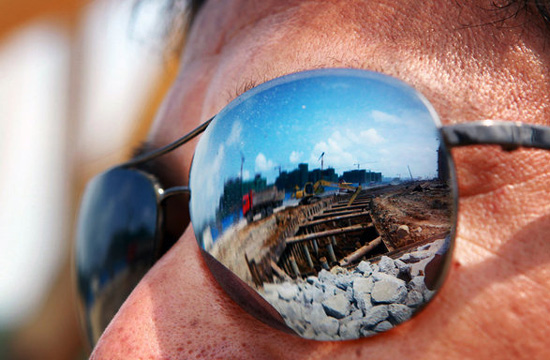 A truck driver’s sunglasses show the reflection of a construction site in Hengqin Island, Zhuhai city, Guangzhou province on June 3, 2012.[Photo/CFP]