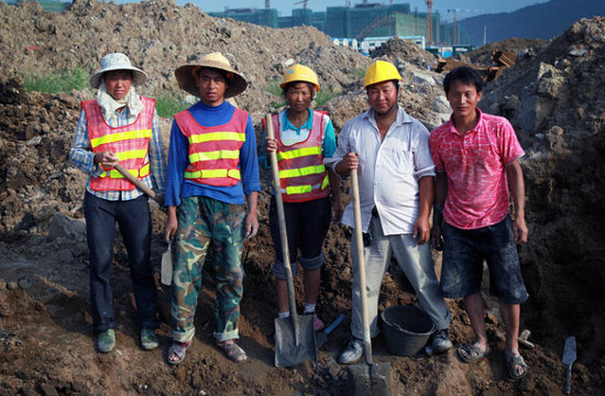 Workers smile to the camera at a construction site in Hengqin Island, Zhuhai city, Guangzhou province on June 3, 2012.[Photo/CFP]