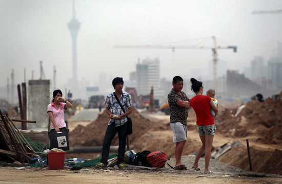 Workers wait for a car by the road of a construction site in Hengqin Island, Zhuhai city, Guangzhou province on June 15, 2012.[Photo/CFP] 