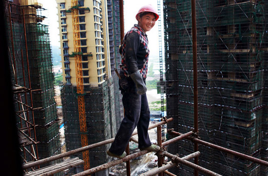  A female worker stands on scaffolding for aerial work on a construction site in Hengqin Island, Zhuhai city, Guangzhou province on June 15, 2012. [Photo/CFP