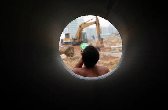 A worker drinks water on a construction site in Hengqin Island, Zhuhai city, Guangzhou province on June 15, 2012. [Photo/CFP]