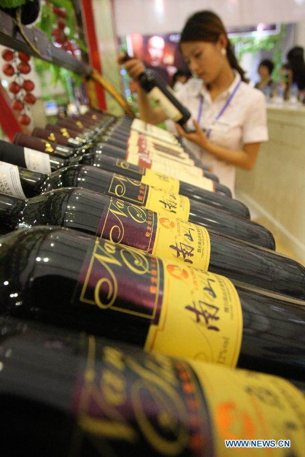 A visitor looks at a product displayed at an international wine expo in Yantai, east China&apos;s Shandong Province, June 28, 2012. 