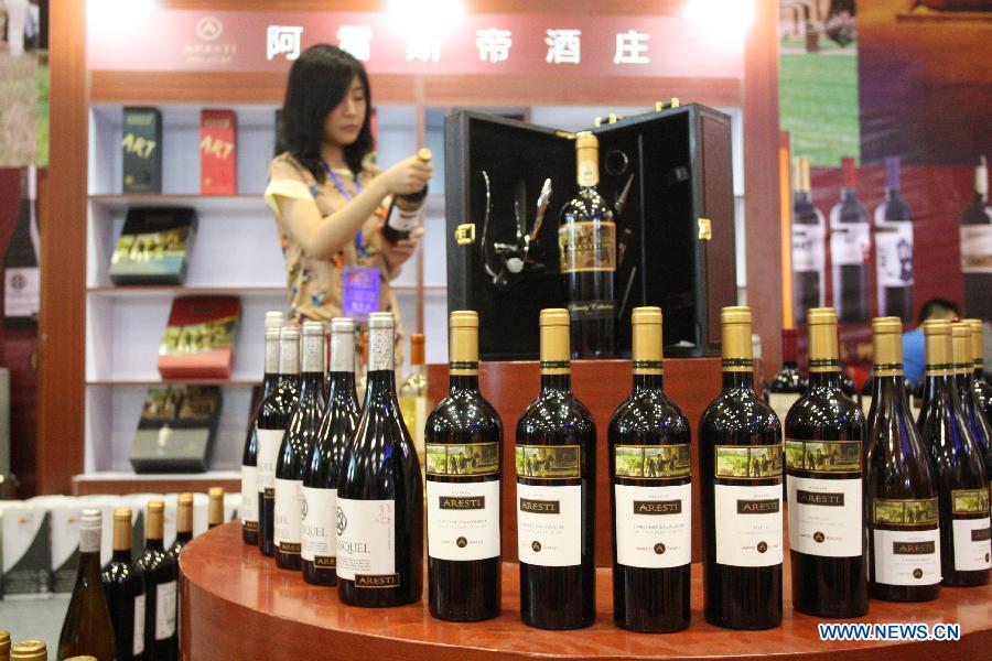 A visitor looks at a product displayed at an international wine expo in Yantai, east China's Shandong Province, June 28, 2012. 