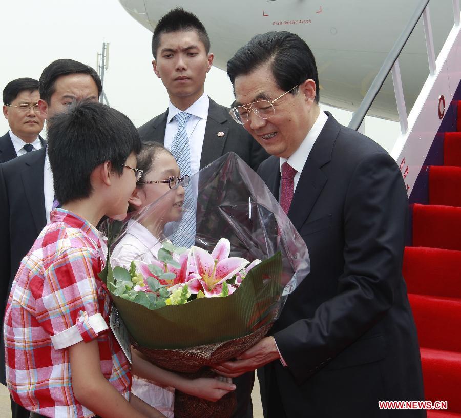 Hong Kong children present flowers to Chinese President Hu Jintao (1st R) upon his arrival at Hong Kong International Airport in Hong Kong, south China, June 29, 2012