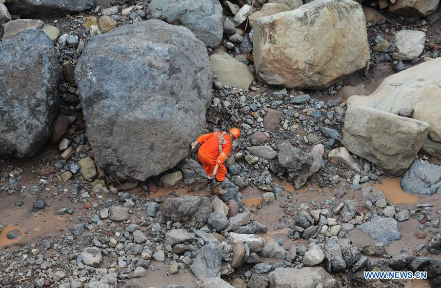 A rescuer searches for missing people at a construction zone of the Baihetan Hydropower Station in Ningnan county, southwest China&apos;s Sichuan Province, June 29, 2012. At least three people are confirmed dead and 38 others are still missing after a rain-triggered mudslide hit the construction zone Thursday morning.