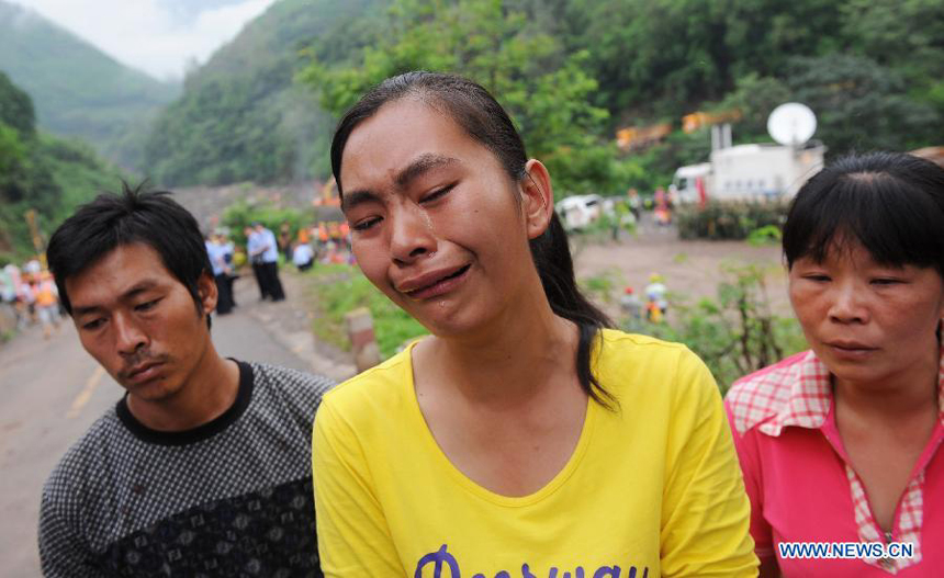 Relatives of missing people wait for messages at the Baihetan Hydropower Station in Ningnan county, southwest China&apos;s Sichuan Province, June 29, 2012. At least three people are confirmed dead and 38 others are still missing after a rain-triggered mudslide hit the construction zone Thursday morning.