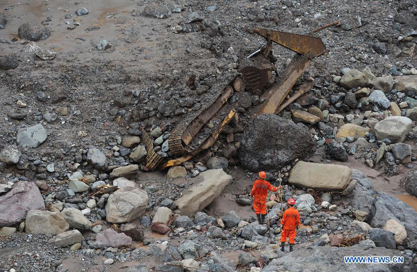 Rescuers search for missing people at a construction zone of the Baihetan Hydropower Station in Ningnan county, southwest China&apos;s Sichuan Province, June 29, 2012. At least three people are confirmed dead and 38 others are still missing after a rain-triggered mudslide hit the construction zone Thursday morning. 