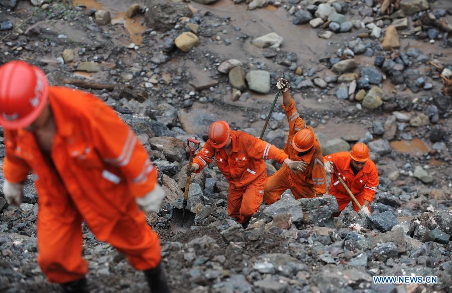 Rescuers search for missing people at a construction zone of the Baihetan Hydropower Station in Ningnan county, southwest China&apos;s Sichuan Province, June 29, 2012. At least three people are confirmed dead and 38 others are still missing after a rain-triggered mudslide hit the construction zone Thursday morning. 