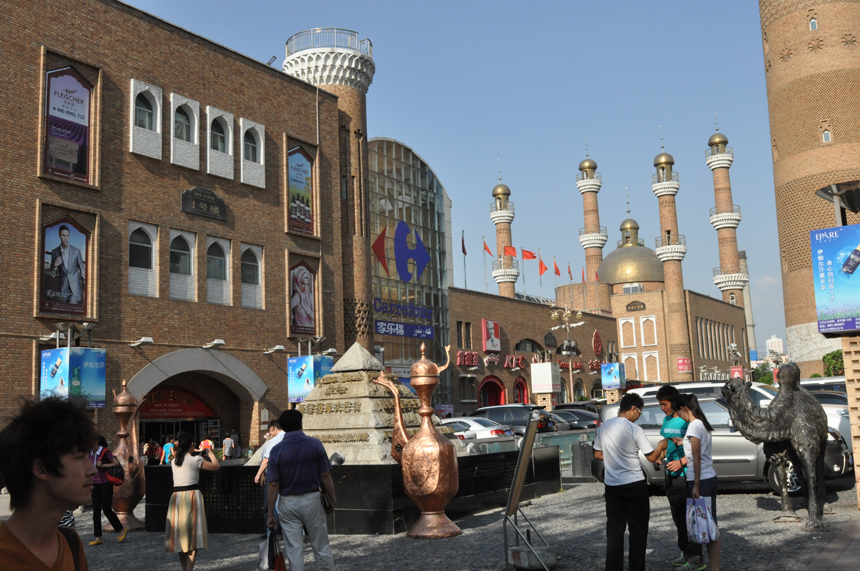 The International Grand Bazaar, the central business district in Urumqi City, Xinjiang Uygur Autonomous Region, is renowned as the biggest dry fruit, jade article and ethnic carpet trade center. Constructed in the traditional Moslem style, the buildings here possess distinctive ethnic culture and are visited by streams of customers every day.