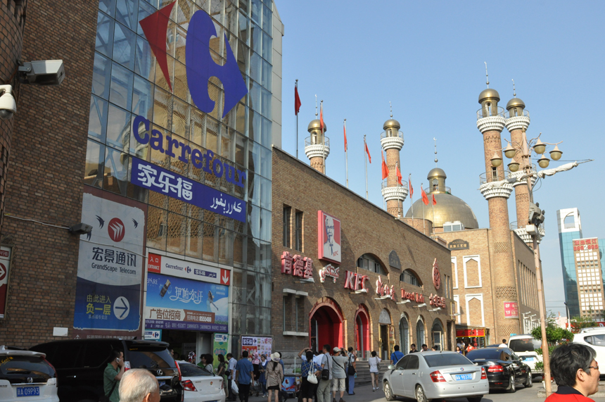 The International Grand Bazaar, the central business district in Urumqi City, Xinjiang Uygur Autonomous Region, is renowned as the biggest dry fruit, jade article and ethnic carpet trade center. Constructed in the traditional Moslem style, the buildings here possess distinctive ethnic culture and are visited by streams of customers every day.