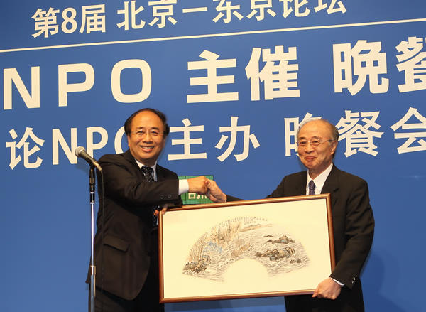  Zhao Qizheng (L), director of the Foreign Affairs Committee of the CPPCC presents a traditional Chinese painting titled 'to help each other overcome the difficulties' to Yasushi Akashi, former Under Secretary General of the United Nations during a welcome dinner for the eighth Beijing-Tokyo Forum, sponsored by China Daily and Genron NPO, a Japanese non-profit organization, July 1, 2012. [Photo/chinadaily.com.cn]