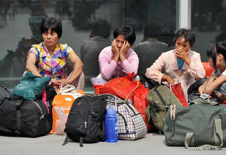 Passengers wait for train at Yinchuan Railway Station in Yinchuan, capital of northwest China's Ningxia Hui Autonomous Region, July 3, 2012