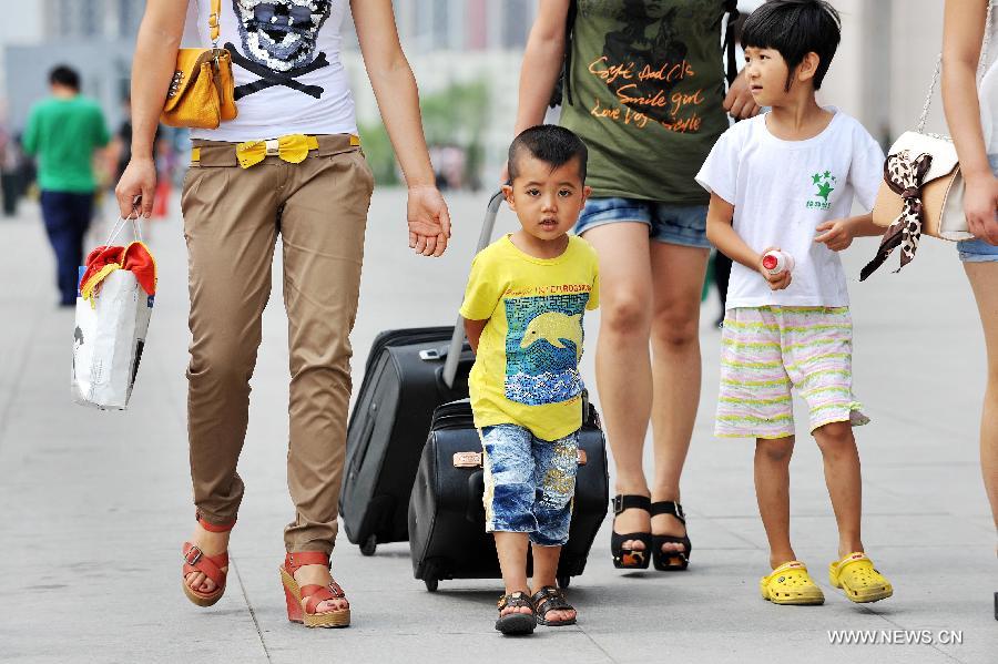 Two little passengers walk at Yinchuan Railway Station in Yinchuan, capital of northwest China's Ningxia Hui Autonomous Region, July 3, 2012