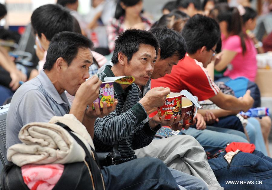 Passengers have lunch at Yinchuan Railway Station in Yinchuan, capital of northwest China's Ningxia Hui Autonomous Region, July 3, 2012