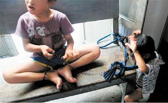 photos of two orphaned children bound by chains were exposed by the media.