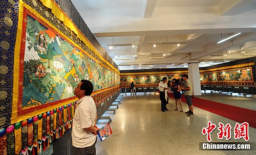 A giant Thangka scroll painting, depicting a historical event witnessing Tibet to become a part of China, was exhibited in Lanzhou, capital of northwest China's Gansu Province, June 18, 2012. [Photo/Chinanews.com]