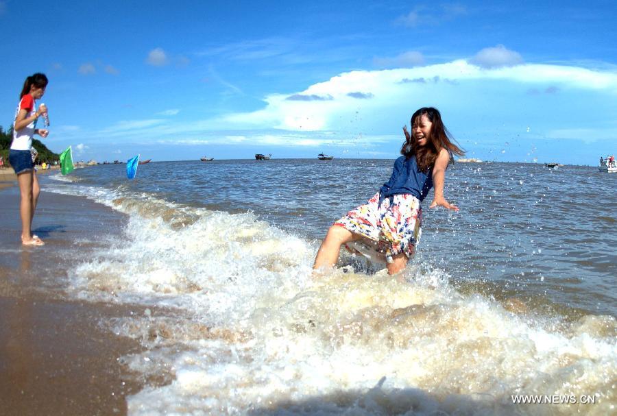 Tourists walk to the beach near Sanniang gulf in Qinzhou, south China's Guangxi Zhuang Autonomous Region, July 3, 2012