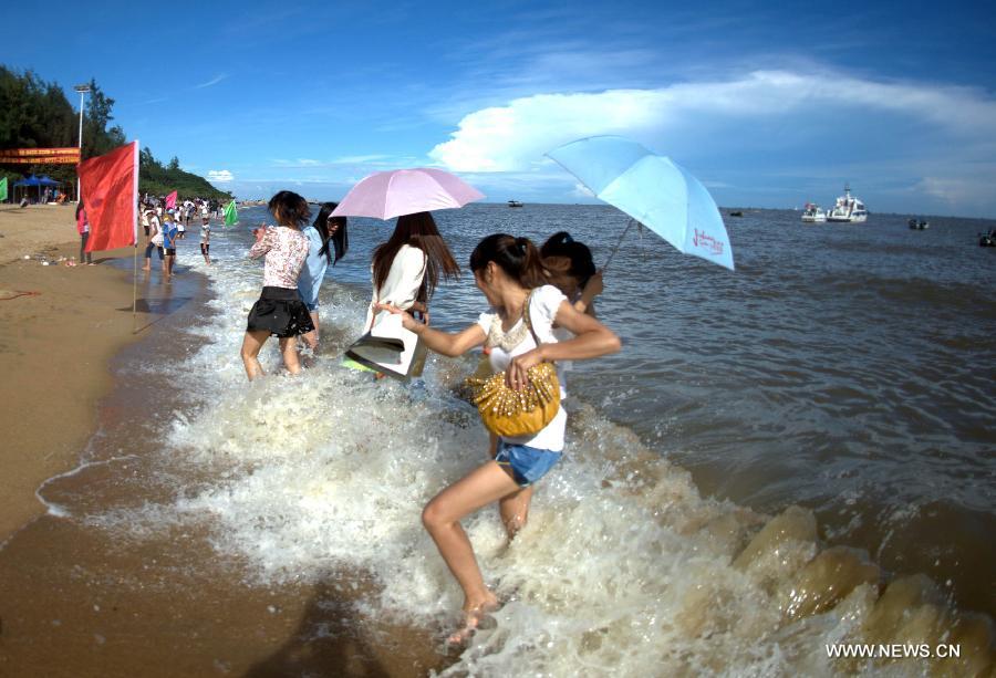 Tourists walk to the beach near Sanniang gulf in Qinzhou, south China's Guangxi Zhuang Autonomous Region, July 3, 2012