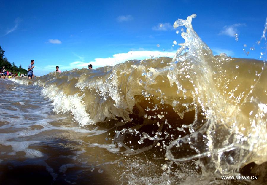 Tourists walk to the beach near Sanniang gulf in Qinzhou, south China's Guangxi Zhuang Autonomous Region, July 3, 2012