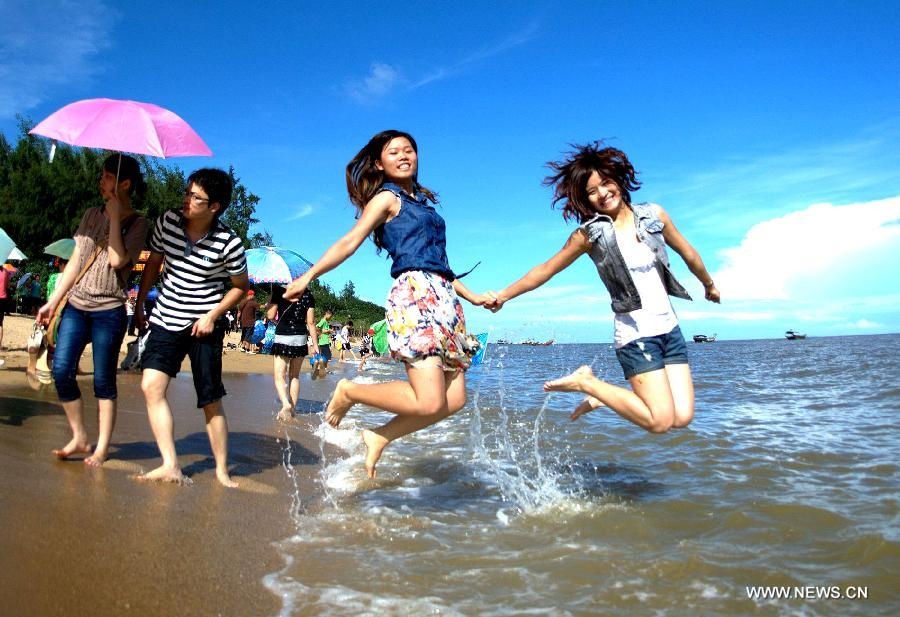 Tourists walk to the beach near Sanniang gulf in Qinzhou, south China's Guangxi Zhuang Autonomous Region, July 3, 2012