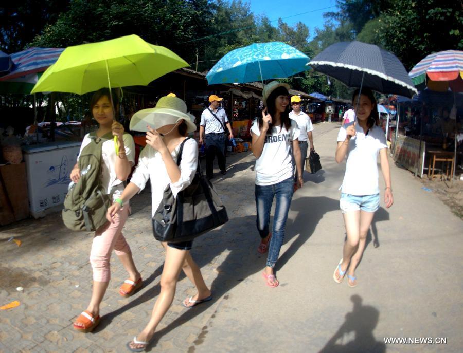 Tourists walk to the beach near Sanniang gulf in Qinzhou, south China's Guangxi Zhuang Autonomous Region, July 3, 2012