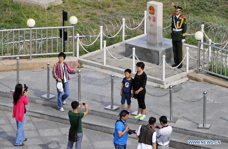 Tourists visit a locomotive at the scenic resort of Sino-Russian border gate in Manzhouli, north China's Inner Mongolia Autonomous Region, July 3, 2012