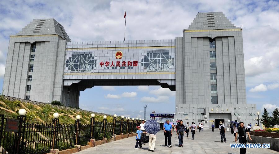 Tourists visit a locomotive at the scenic resort of Sino-Russian border gate in Manzhouli, north China's Inner Mongolia Autonomous Region, July 3, 2012