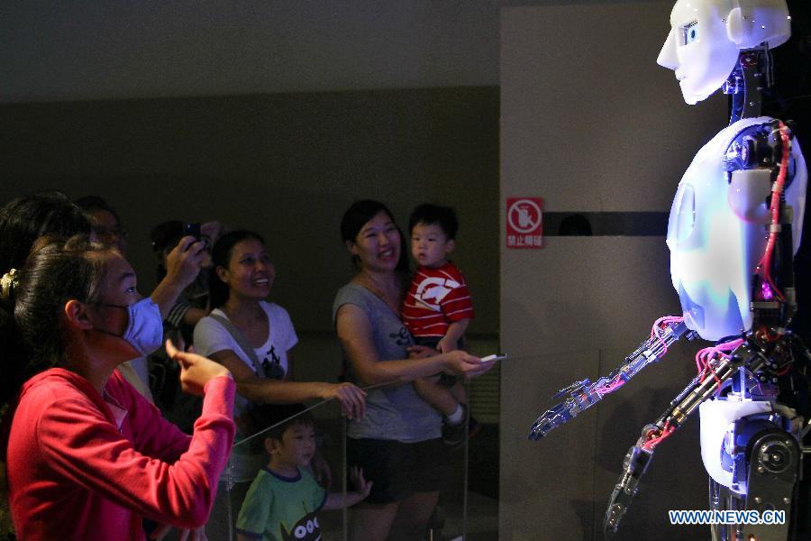 Visitors communicate with a singing robot during the Robot Story Expo in Taipei, southeast China's Taiwan, July 4, 2012.