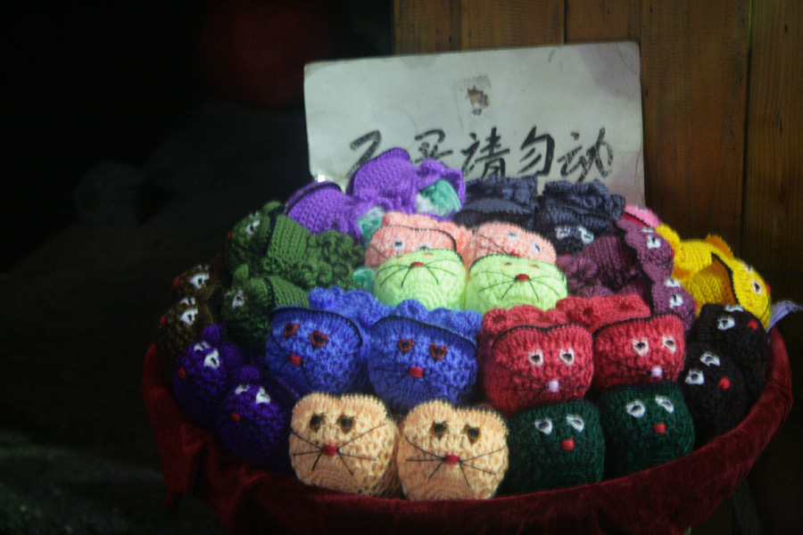 Cat-like shoes made from knitting wool are displayed in a commercial street of Fenghuang (phoenix) ancient town on June 28. [CnDG by Jiao Meng]