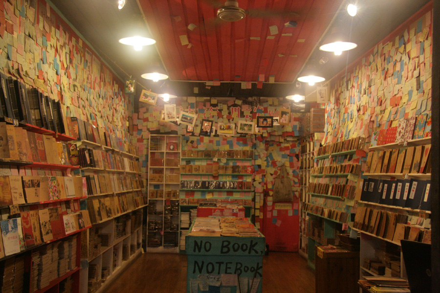 A shop sells notebooks, with lots of post-it notes decorating the wall. [CnDG by Jiao Meng]