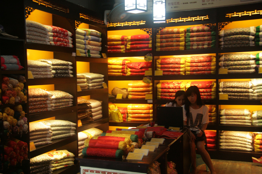 Two shopkeepers of a pillow shop in Fenghuang (phoenix) ancient town, central China’s Hunan Province on June 28. This town, according to New Zealand writer Rewi Alley, is one of the two most picturesque small towns in China, with colorful and hospitable people. [CnDG by Jiao Meng]