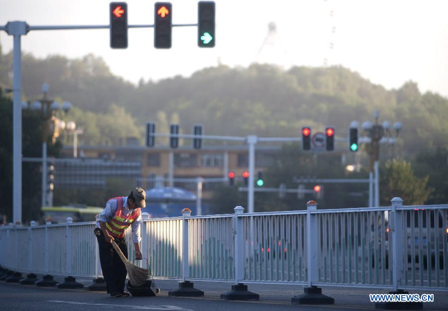 A sanitation worker cleans a road in the morning in Urumqi, capital of northwest China's Xinjiang Uygur Autonomous Region, July 2, 2012