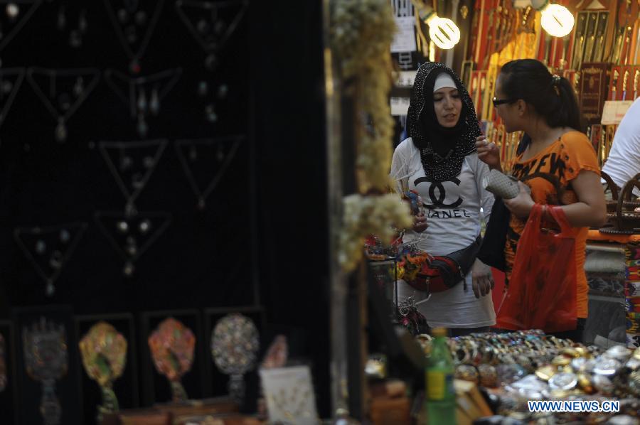 Consumers select souvenirs at the Xinjiang International Grand Bazaar in Urumqi, capital of northwest China's Xinjiang Uygur Autonomous Region, July 2, 2012