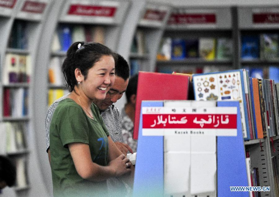 Two readers select books at a bookstore in Urumqi, capital of northwest China's Xinjiang Uygur Autonomous Region, July 2, 2012