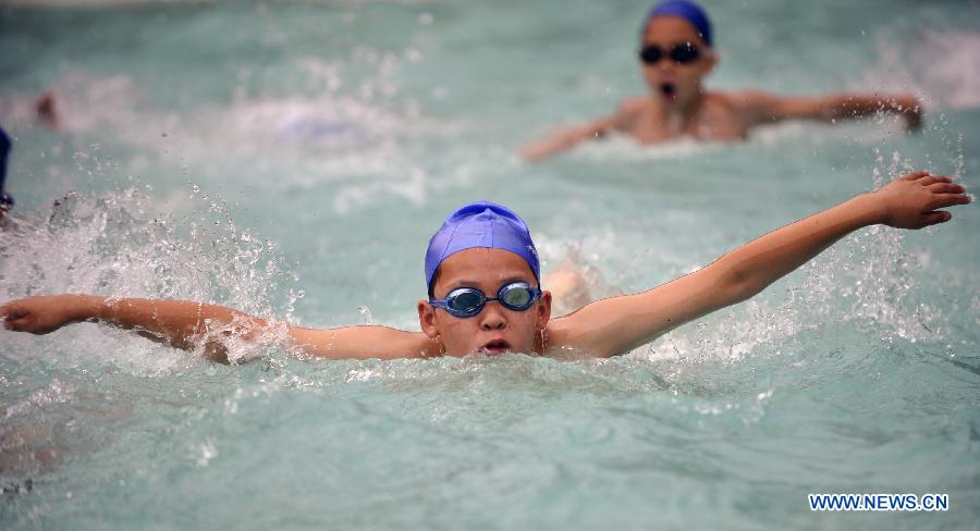 Children swim at a natatorium in Urumqi, capital of northwest China's Xinjiang Uygur Autonomous Region, July 2, 2012