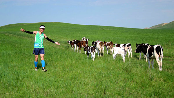 A competitor takes time out to pose with the cows. [Photo: CRIENGLISH.com/William Wang]